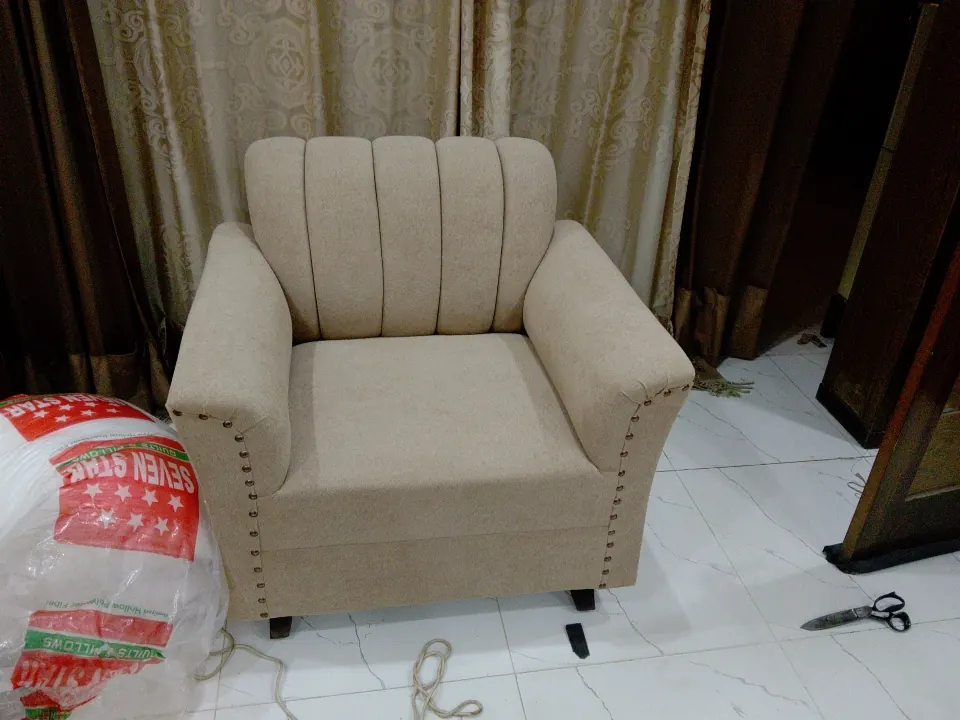 A beige channel-back armchair with nailhead trim